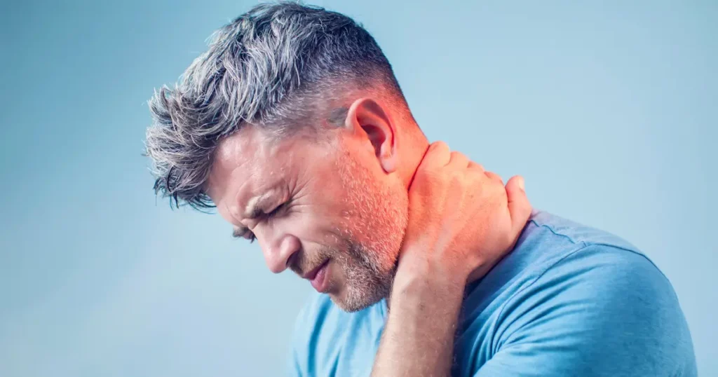 Man grasping his neck in pain. The pain in the neck is radiating into his head causing a headache.