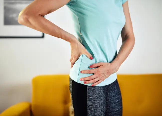 Woman holding her hip and her back in pain and discomfort