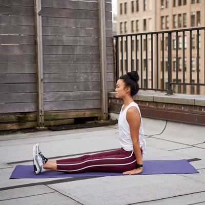 Animation demonstrating the sitting piriformis stretch with a young woman sitting with one leg crossed over the other and pulling her knee toward her opposite shoulder.