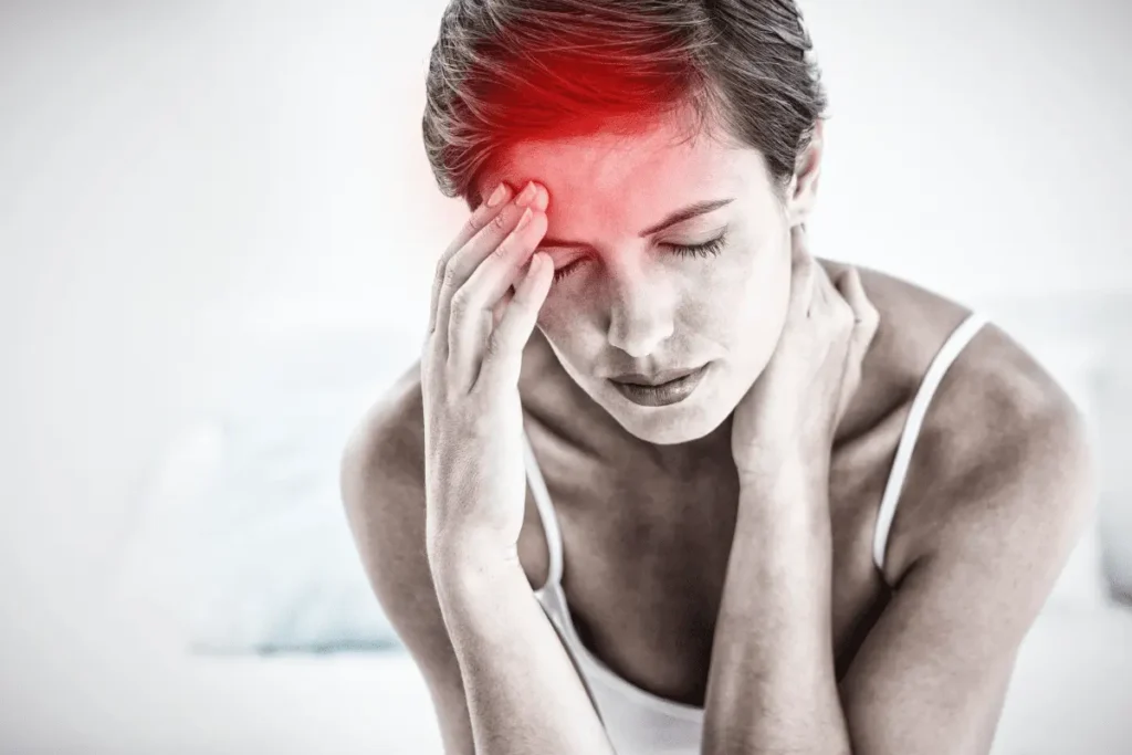 Woman holding her head in pain due to a headache caused by neck pain